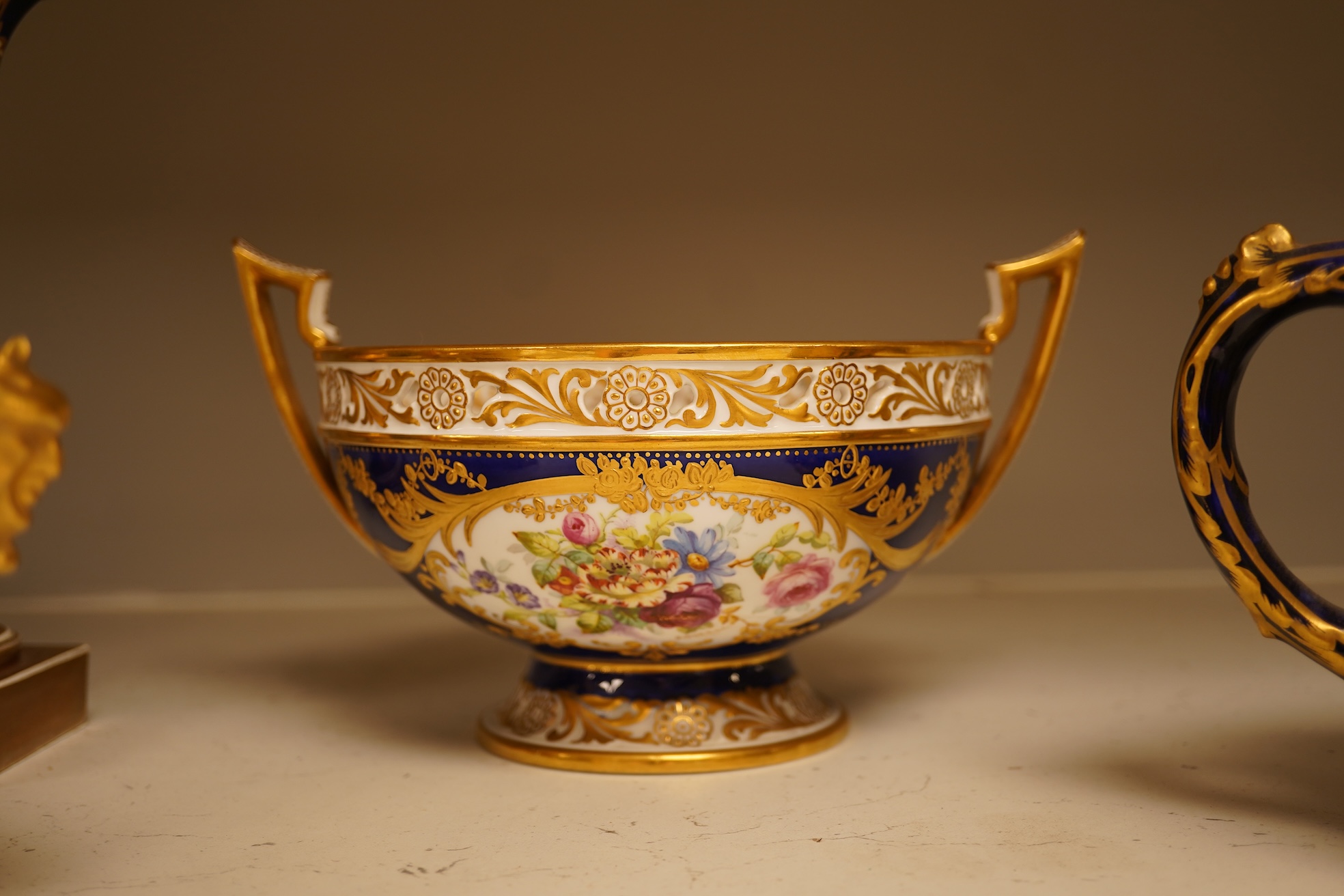 A collection of Royal Crown Derby, to include a two handled bowl, a fluted pedestal vase, saucer with landscape central cartouche etc (5). Vase 19cm high.